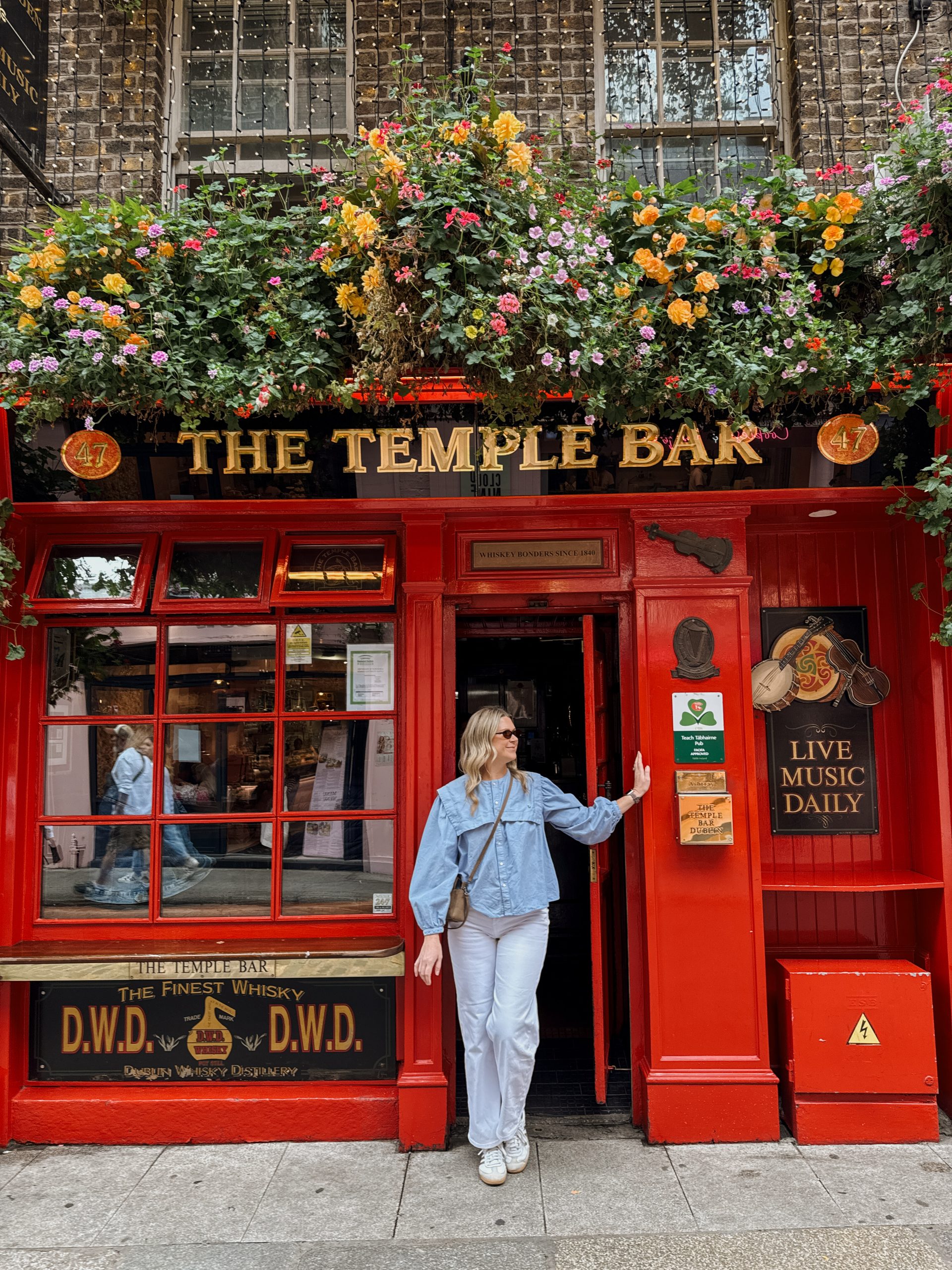 Woman standing in front of Temple Bar in Dublin, Ireland