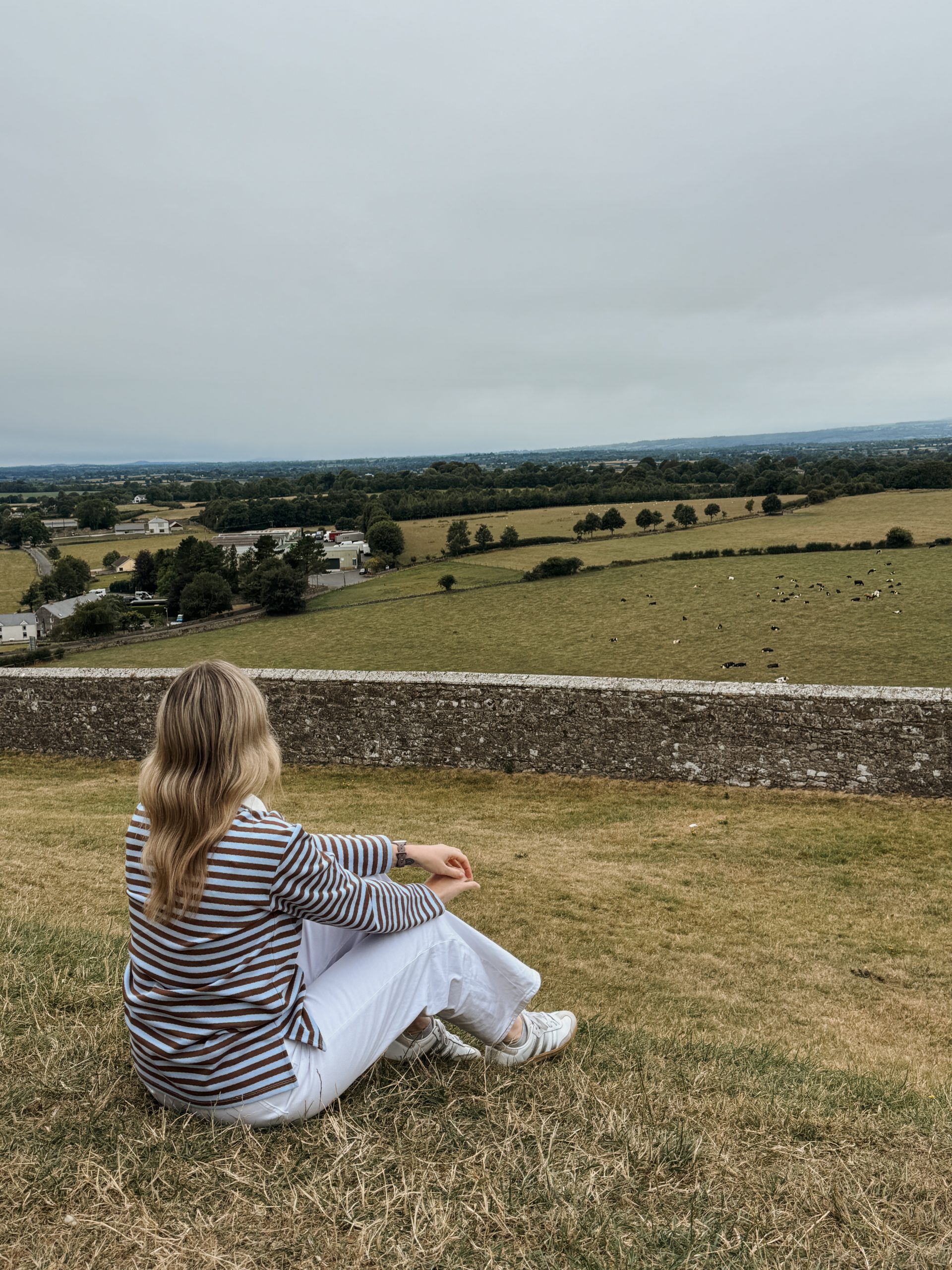 Woman looking out at Irish countryside at the Rock of Cashel in Tipperary, Ireland
