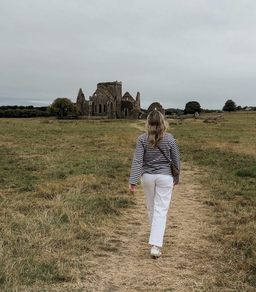 Woman walking towards Hore Abbey in Tipperary, Ireland