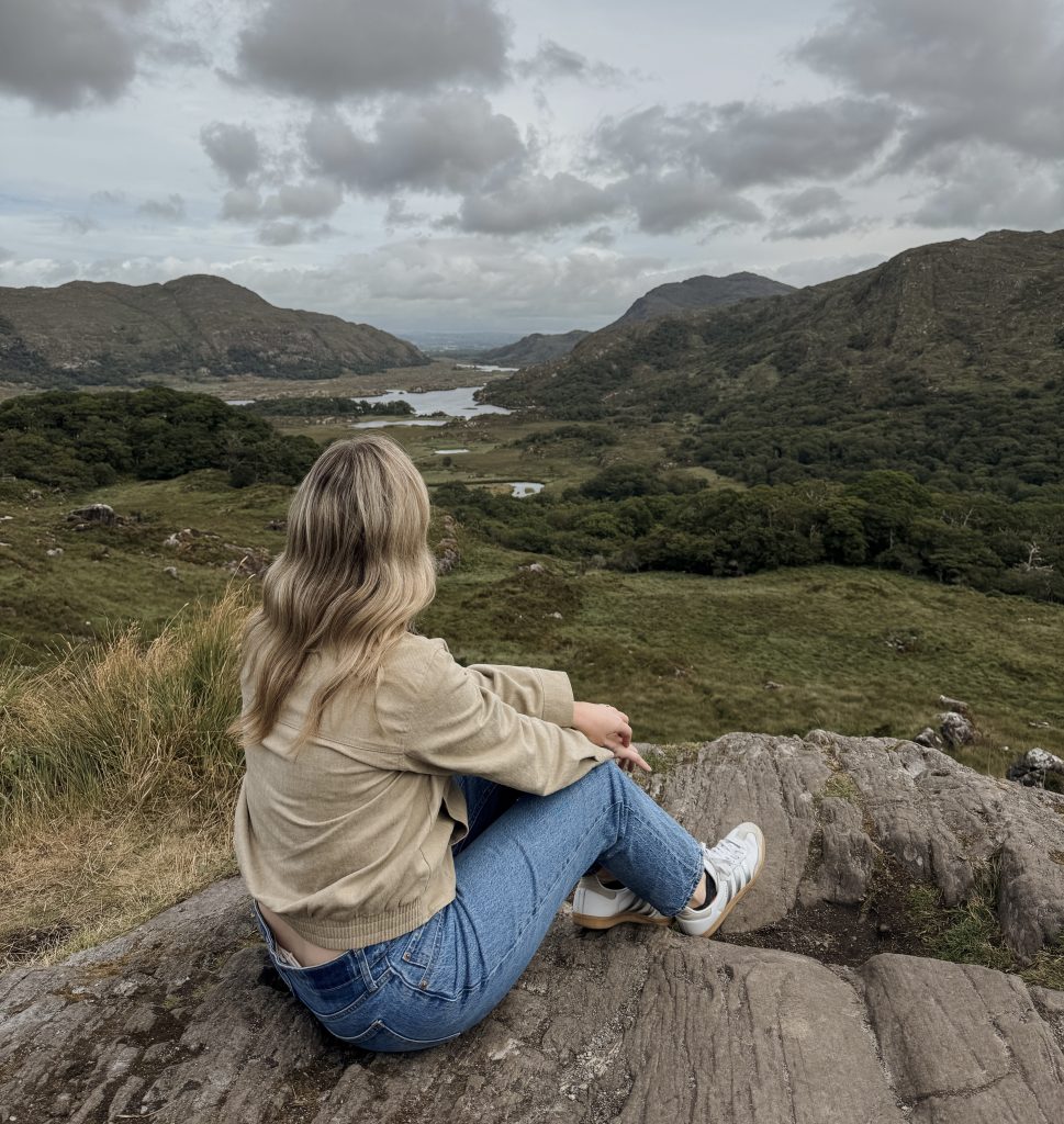 Woman sitting at Ladies View on the Ring of Kerry in Ireland