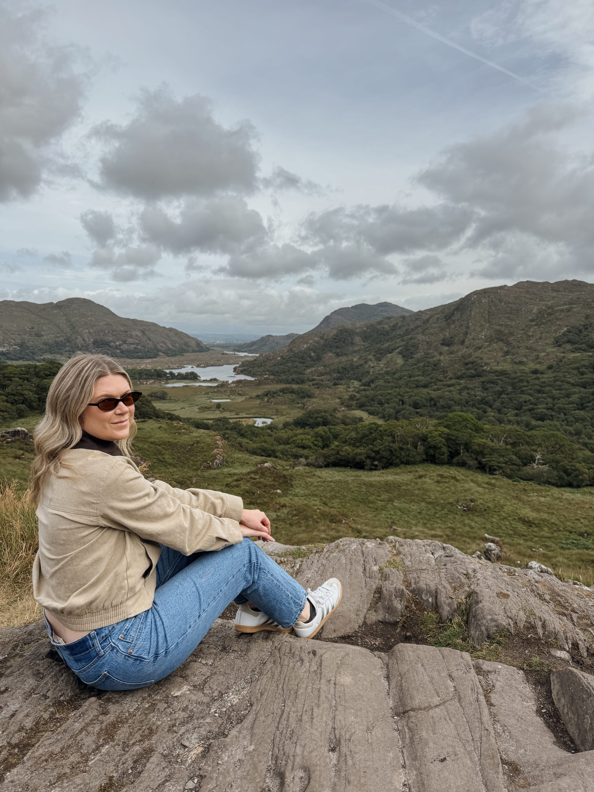 Woman sitting at Ladies View on the Ring of Kerry in Killarney, Ireland