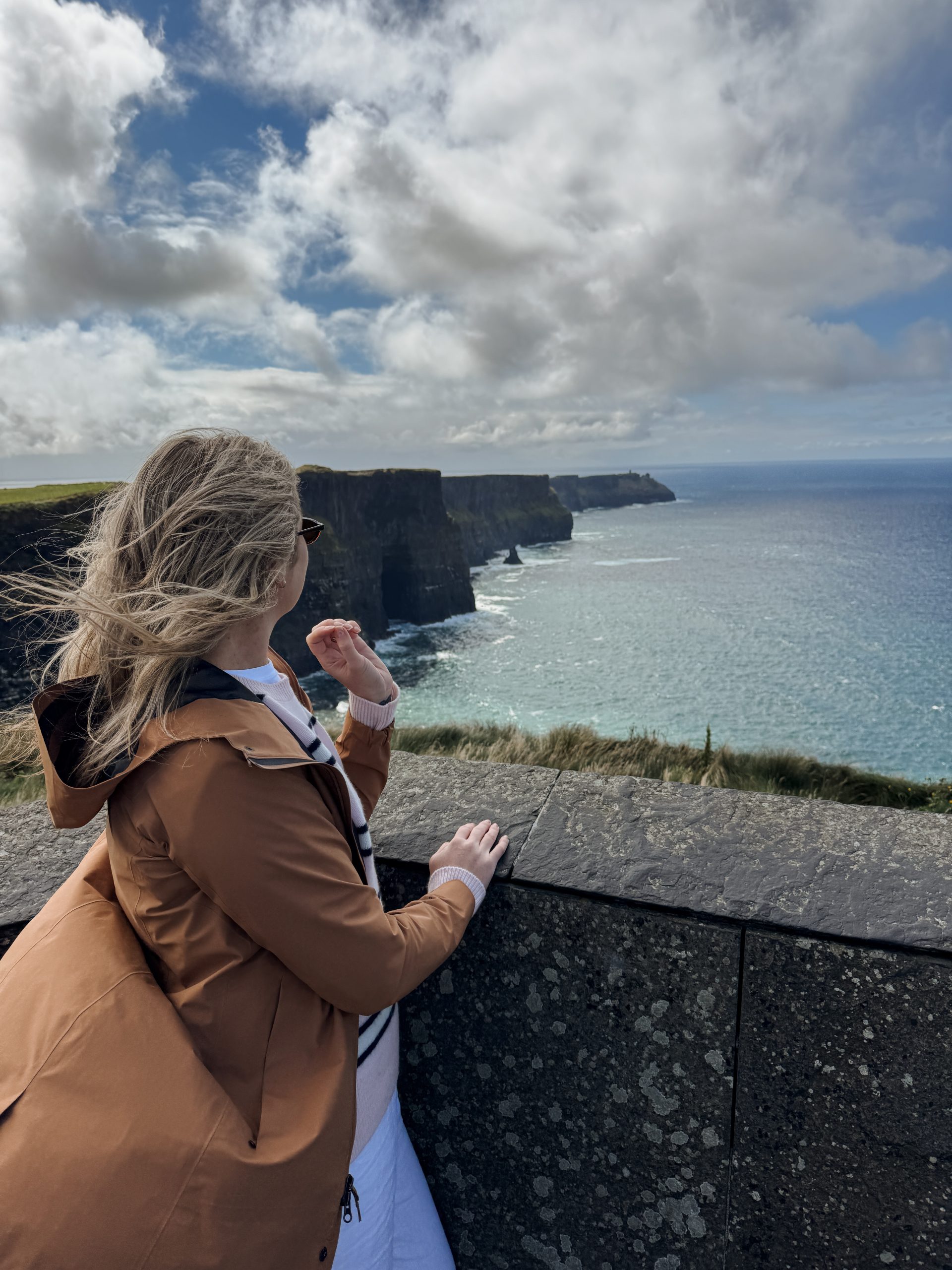 Woman looking out at the Cliffs of Moher in Ireland