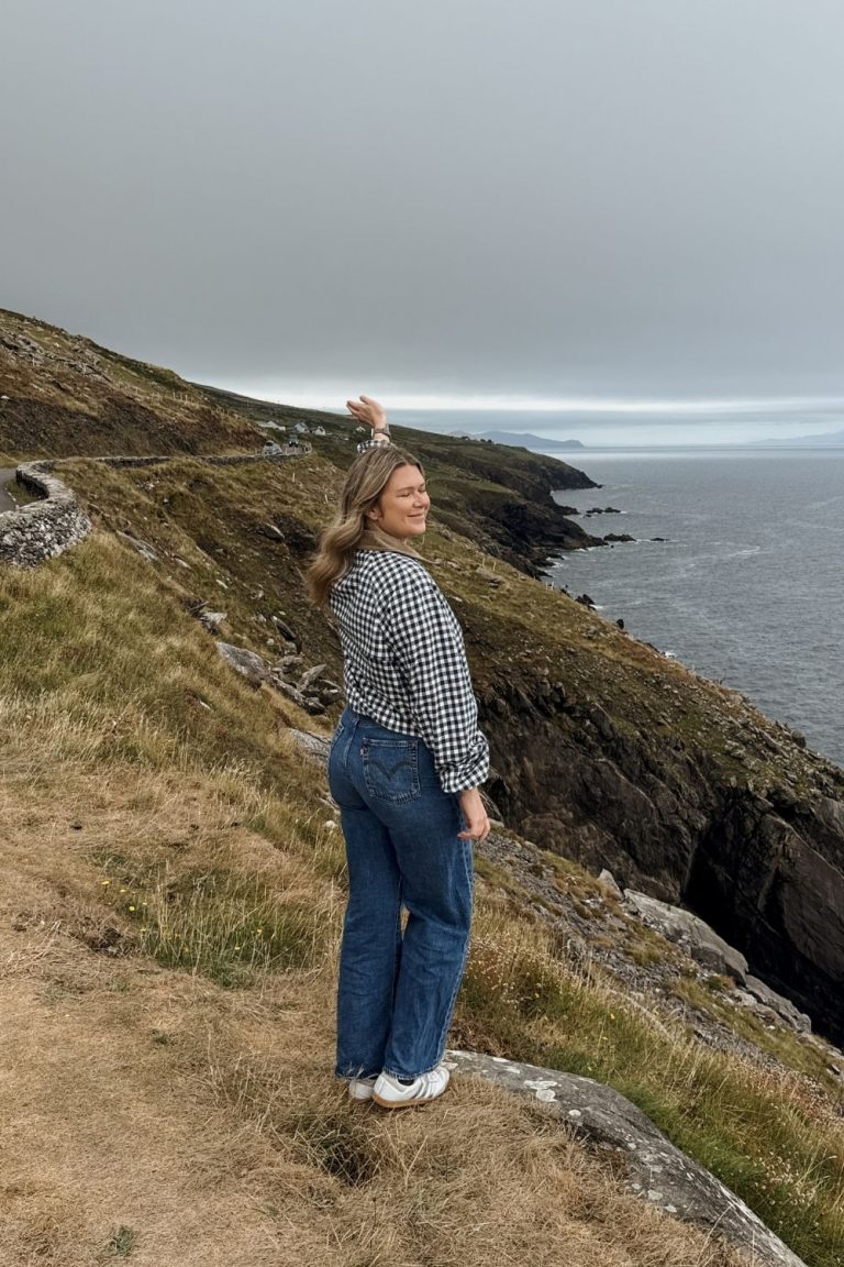 Woman standing at cliff on Slea Head Drive in Dingle Peninsula