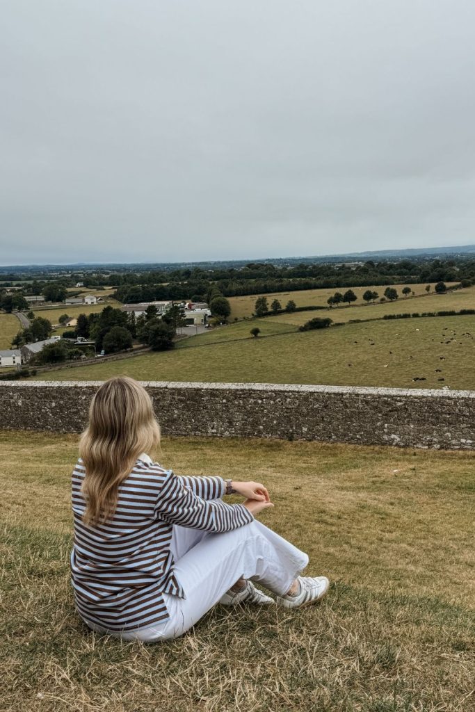 Woman looking at surrounding countryside of the Rock of Cashel in Tipperary, Ireland