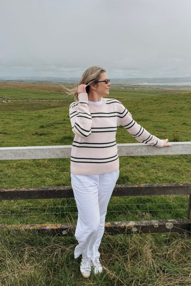 Woman standing at surrounding area of the Cliffs of Moher in Ireland