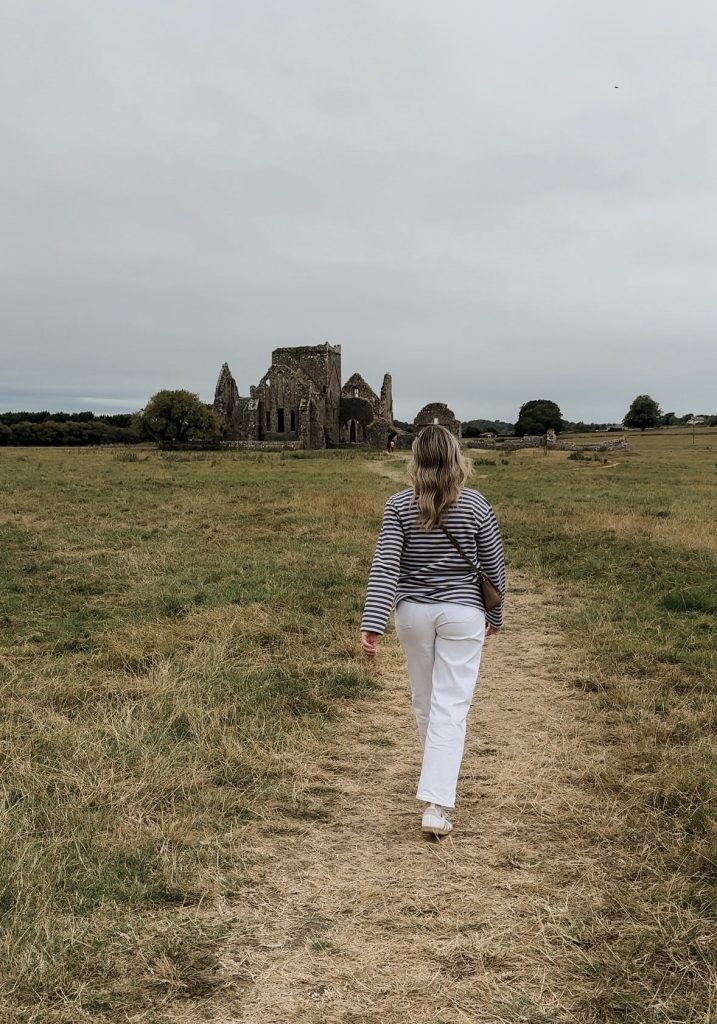 Woman walking towards castle in Tipperary Ireland